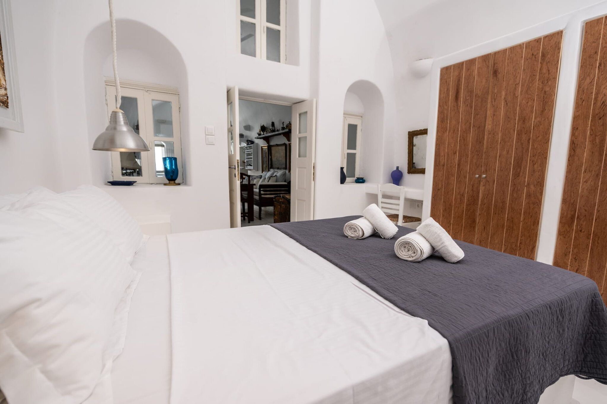 A hotel room with a bed, a desk, and a wardrobe.