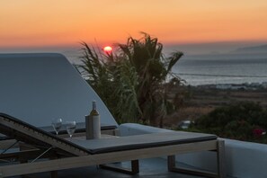 A lounge chair with a bottle and glasses, overlooking a sunset over the sea. - Villa Meloria, Divine Sea Views, Private Pool, Furnished Terrace, Finikia (Santorini)