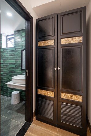 A dark wooden wardrobe with a mirrored panel and a small window. - An Dinh La Maison by Teky House (Thuan Hoa)