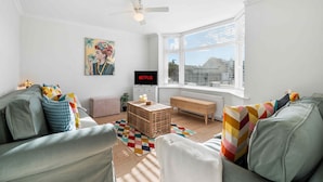 A modern living room with a sofa set, a coffee table, and a television displaying 'NETFLIX'. - Sea Palm By My Getaways (Lancing)