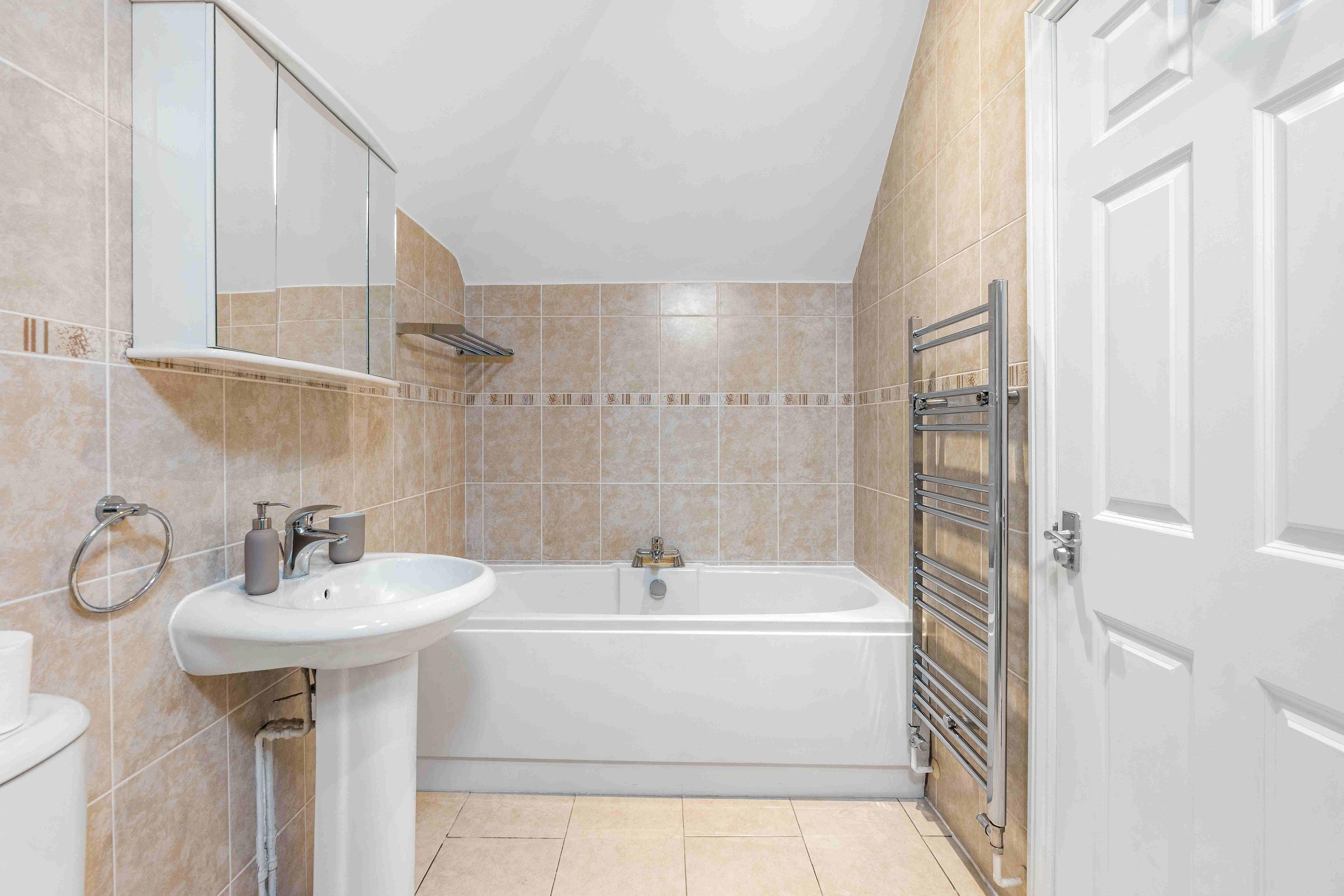 A modern bathroom with a bathtub, a sink, and a mirror.