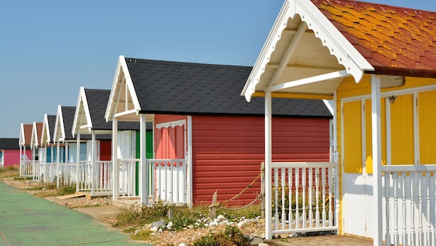 A row of beach huts with white railings and colorful facades. - Sea Palm By My Getaways (Lancing)