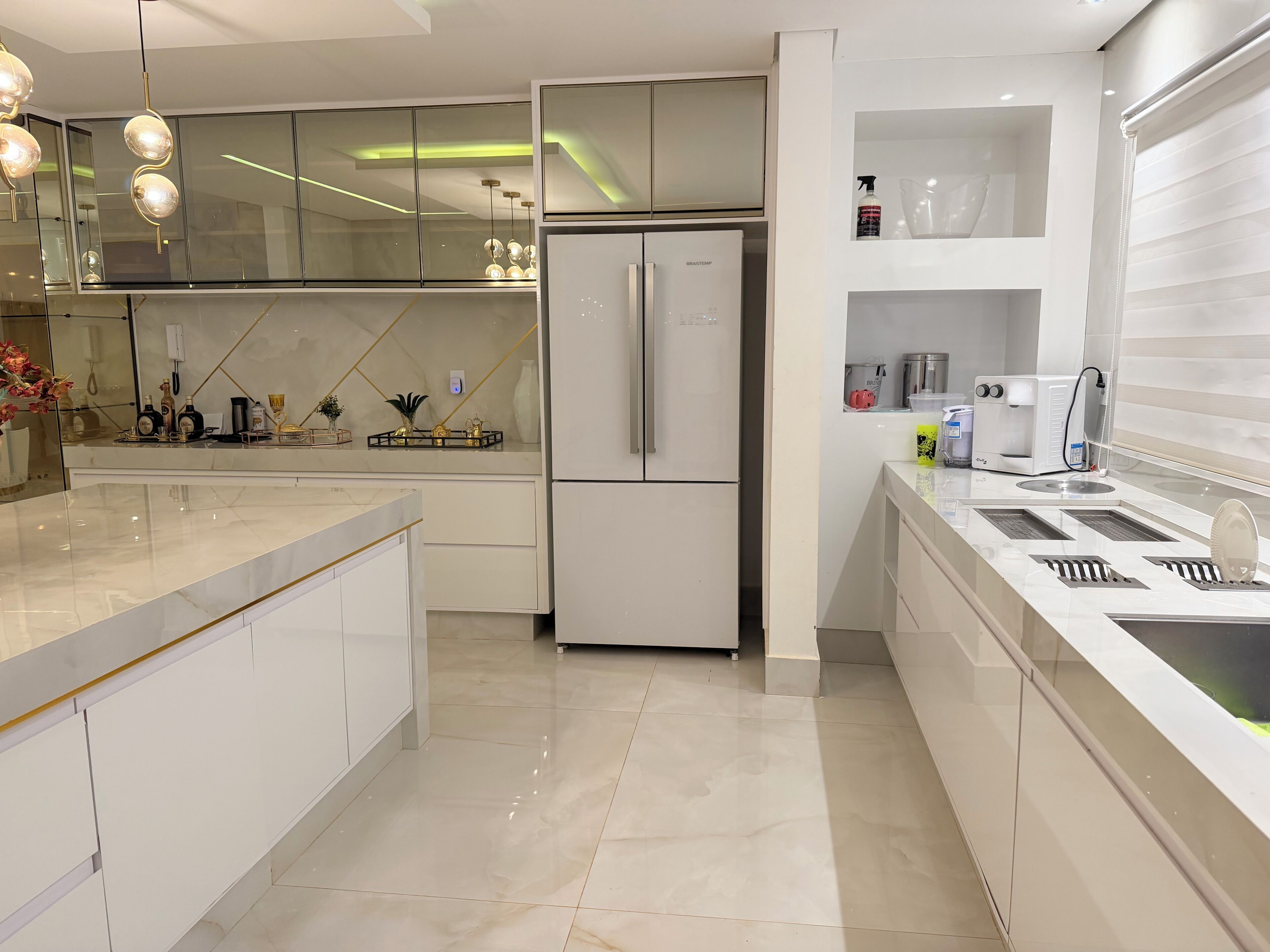 Eine moderne Küche mit Kühlschrank, Spüle und einer Arbeitsplatte mit verschiedenen Gegenständen.