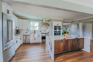 A kitchen with white cabinets, a central island, and a stove.