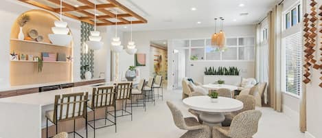A modern interior with a kitchen, dining area, and seating space.