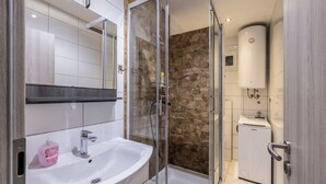 A modern bathroom with a glass-enclosed shower, a white sink, and a built-in heater. - Villa sa bazenom u srcu Splita.. (Split)