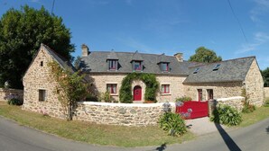 A stone house with a red door, multiple windows, and a small garden. - COTTAGE CLOSE TO THE SEA. Pets allowed, ideal for families (lezardrieux)