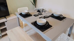 A dining table set with bowls, wine glasses, and cutlery. - Spacious 4 Bed House With 3 Bathrooms & Parking (Bedford)