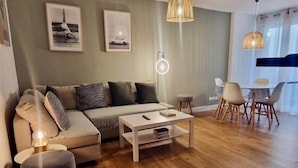 A modern living room with a sofa, coffee table, and dining area. - "Marianne "Nice T3 Central, Air-conditioned with Parking (Sète)