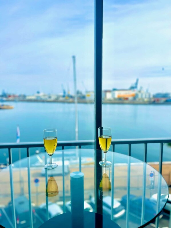 Une table avec deux verres de vin et une vue sur un port.
