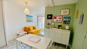 A compact living space with a dining area, a sofa, a kitchenette, and a view through a glass door. - "Ophélia 22" Nice T2 with air conditioning and parking (Sète)