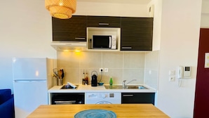 A compact kitchen with a microwave, stove, and sink. - ''Loulou'' T2 modern, bright in the city center, wif parking (Sète)