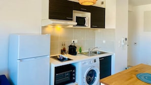 A compact kitchen with a refrigerator, microwave, oven, and washing machine. - ''Loulou'' T2 modern, bright in the city center, wif parking (Sète)