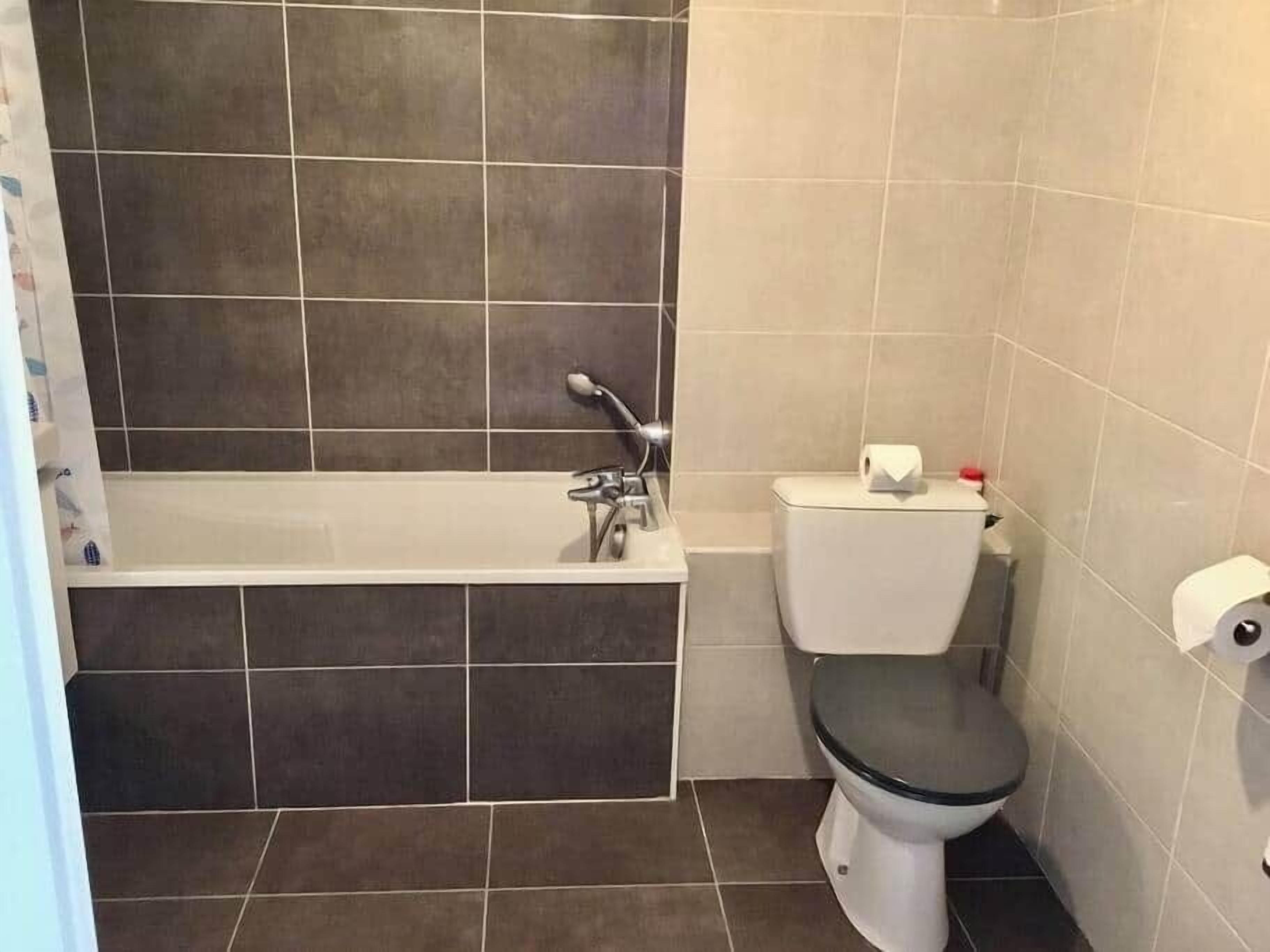 Un baño con bañera, inodoro y zona de ducha.
