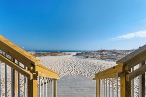 A wooden staircase leading to a sandy beach with a clear sky. - 🐠Beachfront Complex | Community Pool + Covered Parking | Sunrise Village 105 (Gulf Shores)
