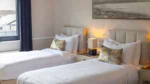 Ein Hotelzimmer mit zwei Betten, einem Nachttisch mit Lampe und einem Bild an der Wand.