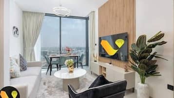 Luxury-Apartment, Balkon, Stadtblick | Wohnbereich | 65-Zoll-Smart-TV mit Kabelempfang