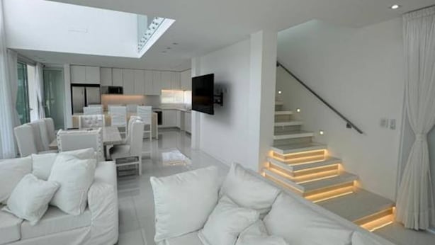 A modern living room with a sofa set and a staircase with illuminated steps. - Serena Boutique Potrero Garay (Alta Gracia)