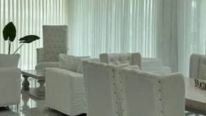 A modern dining area with white furniture and a large window with sheer curtains. - Serena Boutique Potrero Garay (Alta Gracia)