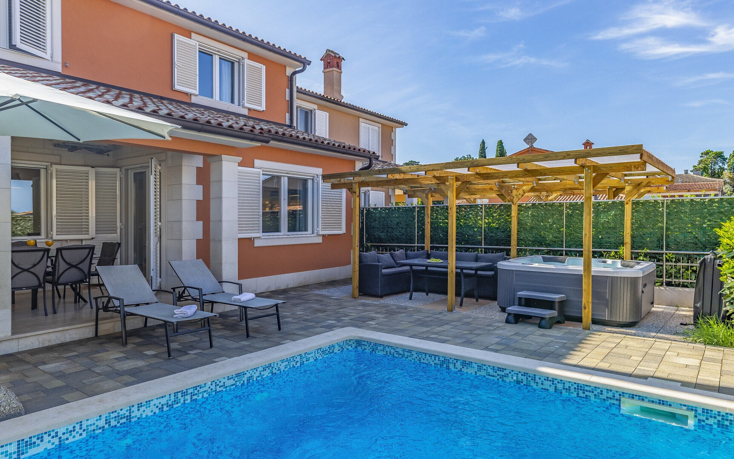 A swimming pool with a pergola and outdoor seating area.