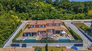 Un edificio de varios pisos con piscina, zona de estar al aire libre y jardín.