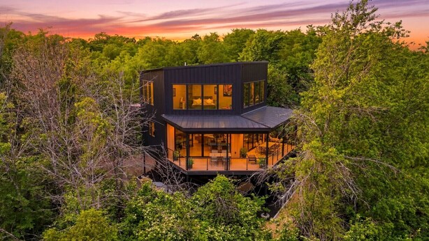 A modern house with a glass facade, surrounded by dense greenery. - The Outlook Treehouse & Lavender Farm (Oxford)