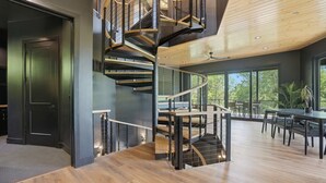 A modern interior with a spiral staircase, wooden flooring, and large windows. - The Outlook Treehouse & Lavender Farm (Oxford)
