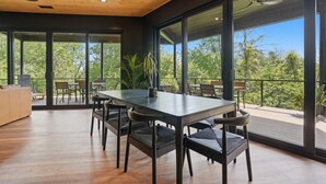 A modern dining area with a large table, chairs, and a view of the outdoors. - The Outlook Treehouse & Lavender Farm (Oxford)