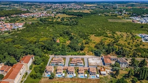 An aerial view of a residential area with a large building complex featuring multiple swimming pools and a central courtyard. - Lotus Elite Villa with Pool & Jacuzzi 3 (Pula)