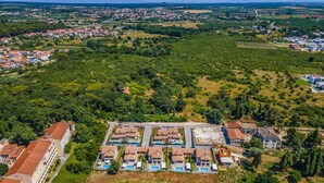 Vista aérea de una zona residencial con un gran conjunto de edificios que cuenta con varias piscinas y un patio central.