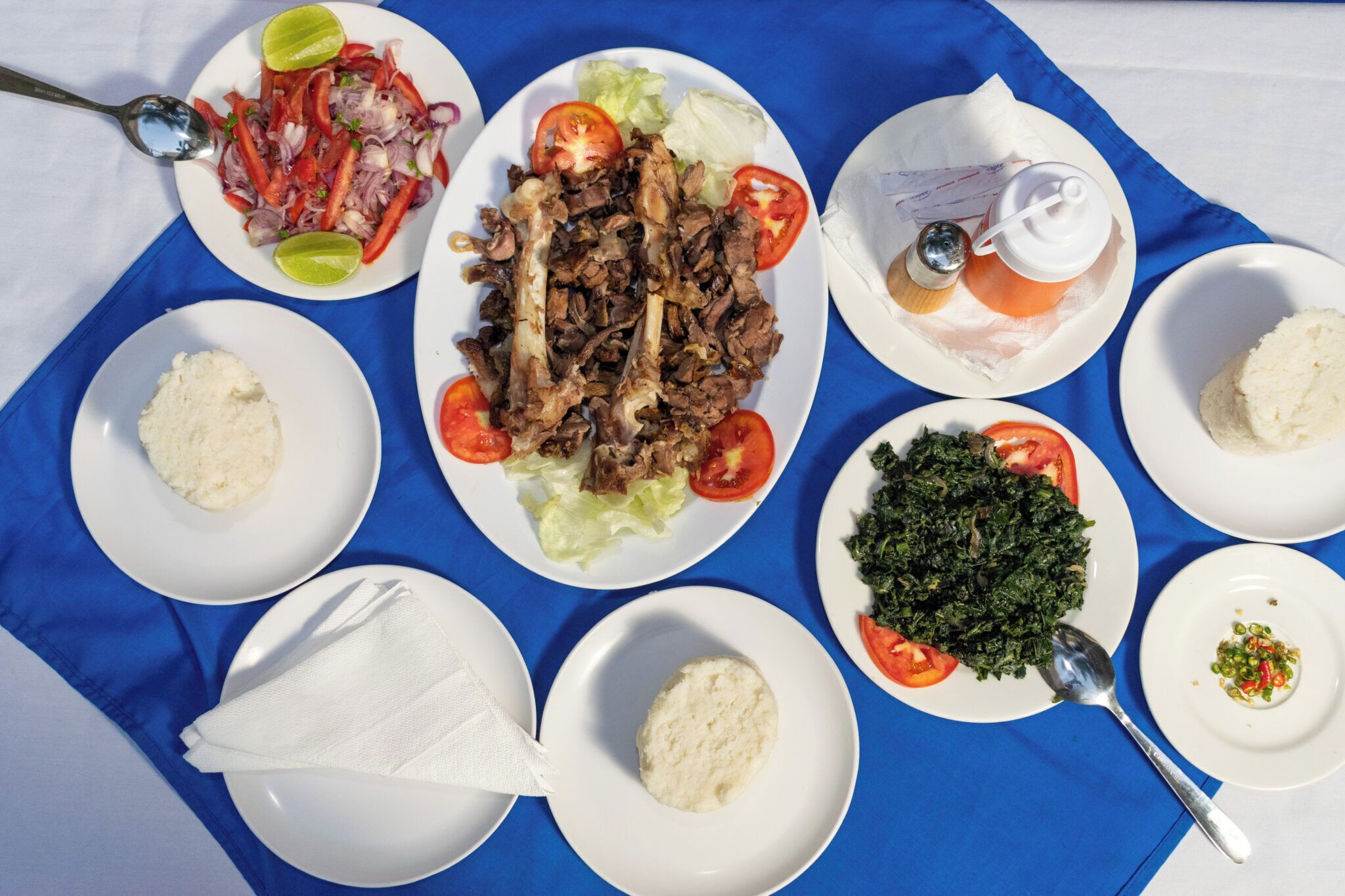A table with various dishes including shredded meat, vegetables, and rice.