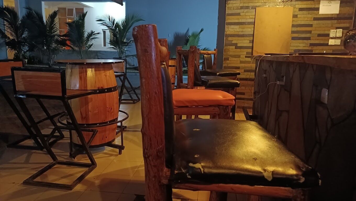 A bar area with wooden furniture, including a bar counter and chairs.