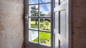 A window with a view of a swimming pool and a grassy yard. - Castle 'Chambre 1' with Shared Terrace, Private Garden and Wi-Fi (La Boixe)