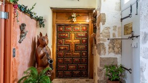 A wooden door with a decorative pattern, a small statue of a dog, and a potted plant beside the door. - Room 2 in Château with Shared Terrace, Private Garden, and Wi-Fi (La Boixe)