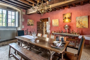 A dining room with a wooden table, benches, and a chandelier. - Castle 'Chambre 3' with Shared Terrace, Private Garden and Wi-Fi (La Boixe)