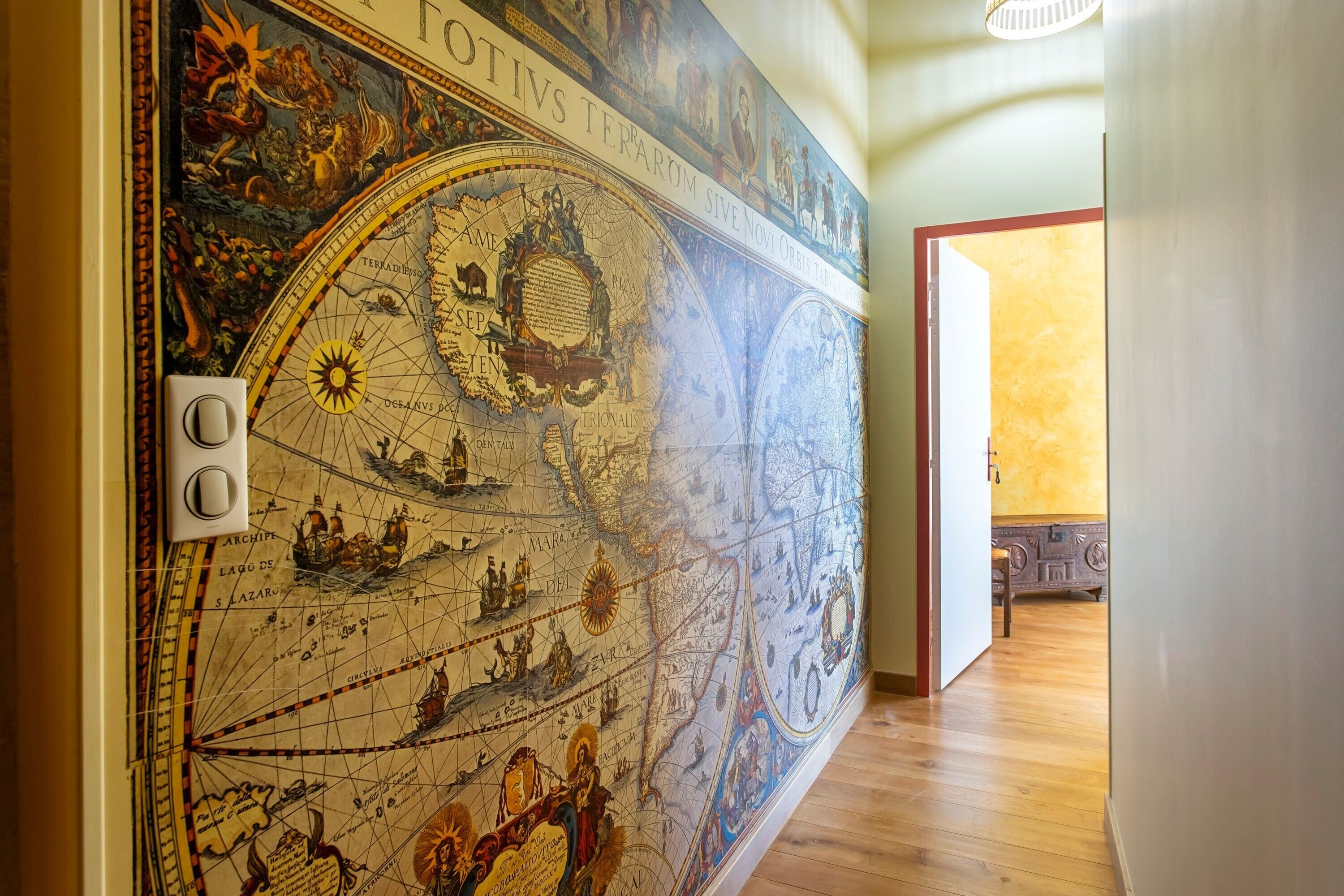 Un mural detallado con un mapa histórico, un interruptor de luz y un piso de madera.