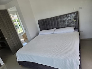 A bedroom with a bed, a dark headboard, and a white bedspread. - Cottage near the village very quiet for the family (Restrepo)