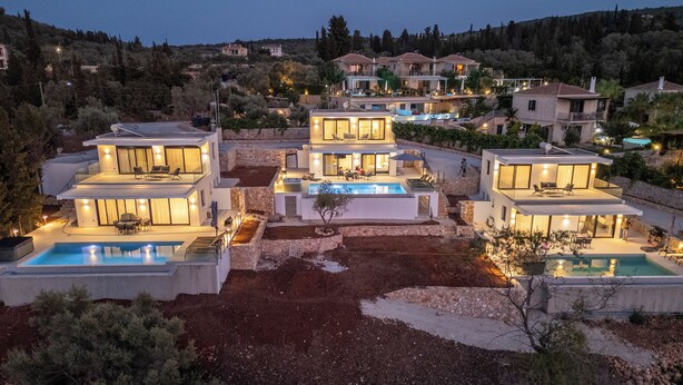 Eine moderne Villa mit Swimmingpool, überdachter Terrasse und Blick auf die umliegende Landschaft.