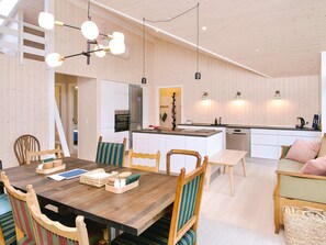 A modern kitchen with white cabinetry, a central island, and pendant lighting. - 4 Star Holiday Home in Gilleleje (Gilleleje)