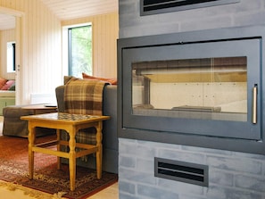 Una sala de estar acogedora con chimenea, una mesa de madera y un espacio de descanso cómodo.