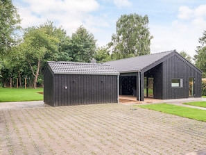 A modern black building with a sloped roof and a covered porch area. - 4 Star Holiday Home in Gilleleje (Gilleleje)