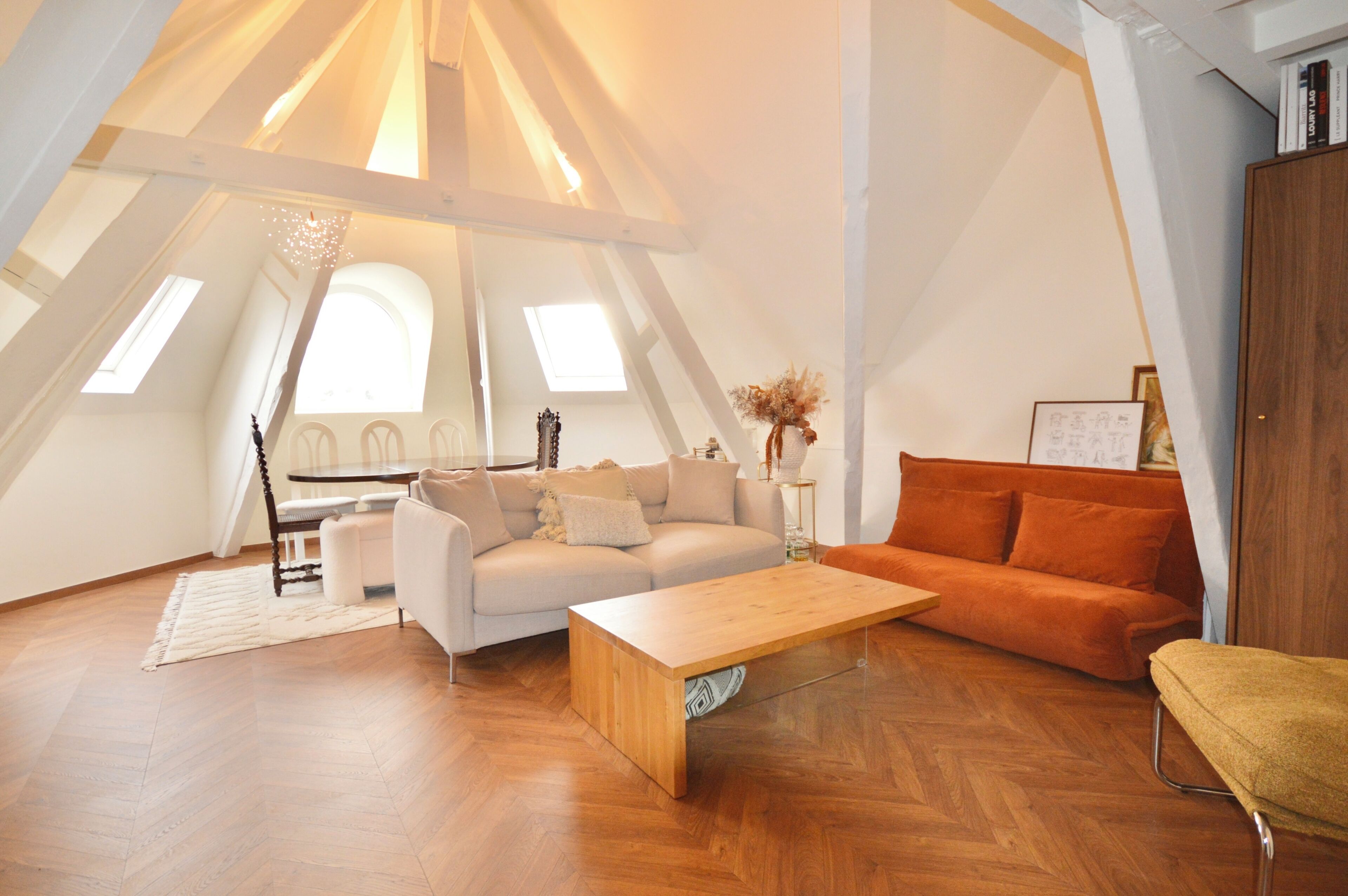 A spacious loft with a high ceiling, a wooden coffee table, a sofa, and a couch.