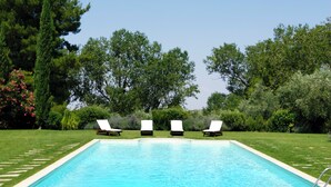 A rectangular swimming pool with a clear blue water surface, surrounded by a well-maintained lawn and various trees. - Masseria dei Paternostro - Private Sicilian Estate with Pool near Corleone (Corleone)