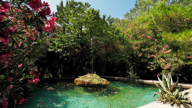 A clear pool surrounded by lush greenery and pink flowers. - Masseria dei Paternostro - Private Sicilian Estate with Pool near Corleone (Corleone)