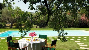 A round table with chairs, a pool, and a garden with trees and flowers. - Masseria dei Paternostro - Private Sicilian Estate with Pool near Corleone (Corleone)