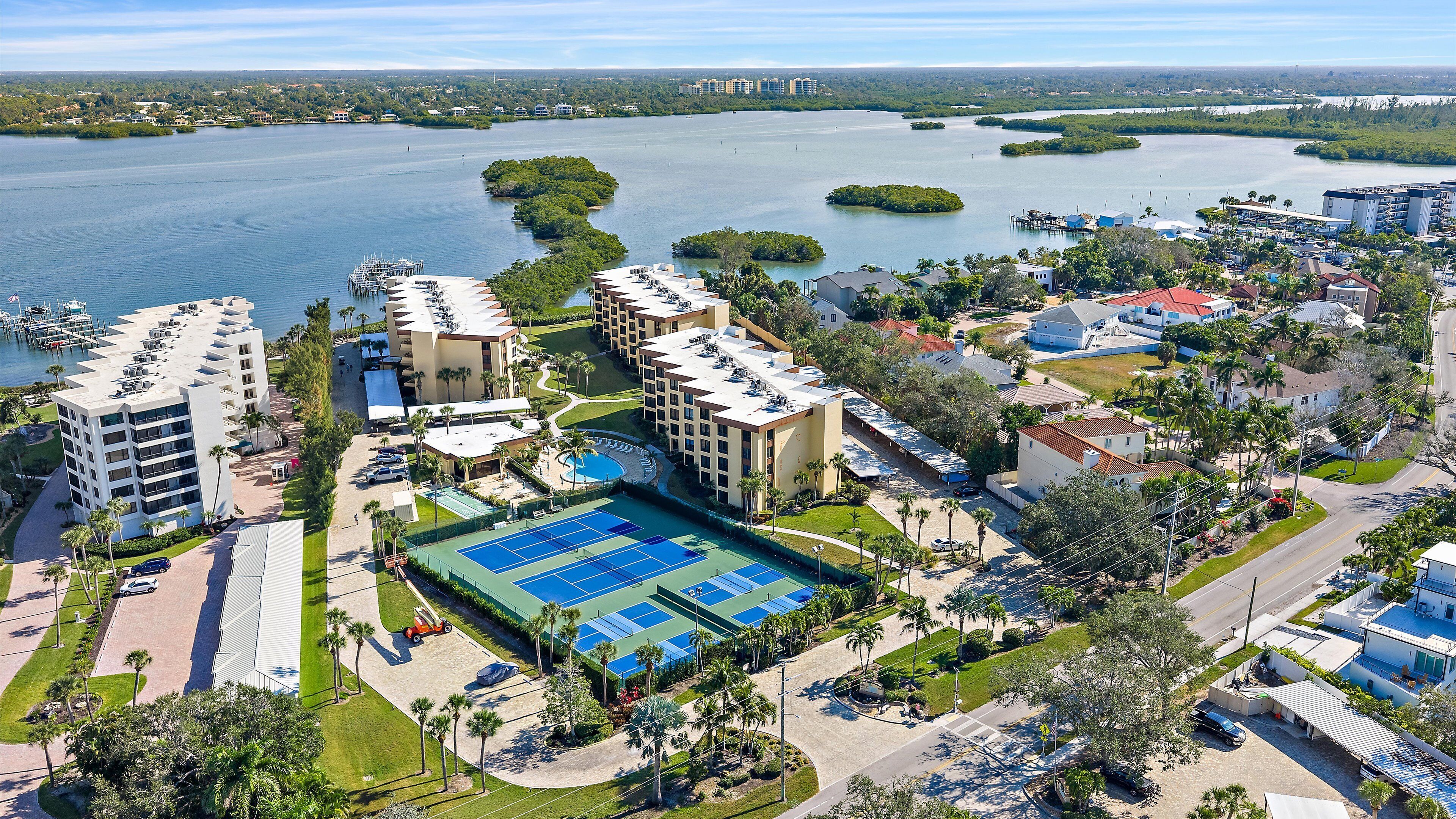 Un complejo turístico con varias edificaciones, una piscina y un puerto deportivo.