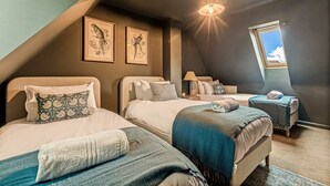 A bedroom with two beds, a skylight, and framed wall art. - The Seven Residence - near Bicester village (Bicester)