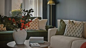 A living room with a sofa, a coffee table with a vase and books, and a floor lamp. - The Seven Residence - near Bicester village (Bicester)