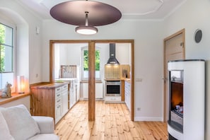 Eine moderne Küche mit Holzboden, weißen Schränken und einem eingebauten Backofen.