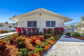 A single-story house with a white exterior, two windows with shutters, and a covered porch. - Modern Studio close to Aventura - Gym (North Miami)